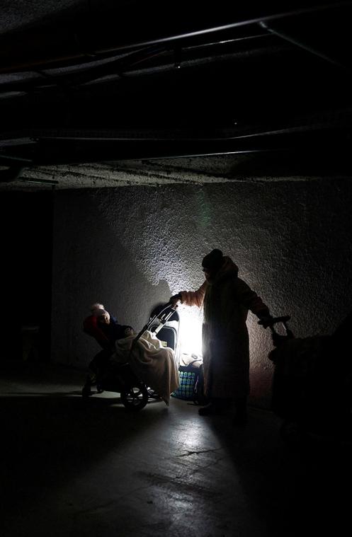 Une femme et ses enfants se réfugient dans un parking souterrain, lors de frappes de missiles et de drones russes, à Kiev, le 20 janvier 2026.