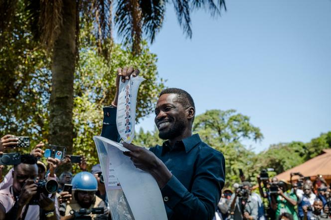 Le leader de l’opposition ougandaise, Robert Kyagulanyi Ssentamu, plus connu sous le nom de Bobi Wine, montre son bulletin de vote avant de le déposer dans l’urne à Kampala, le 15 janvier 2026, lors des élections générales.