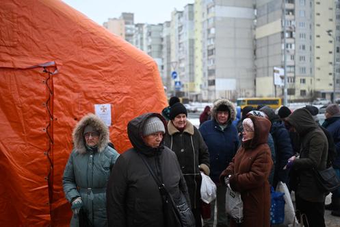 Des habitants font la queue pour recevoir un repas chaud, distribué par des bénévoles dans un quartier de Kiev privé d’eau et d’électricité, le 22 janvier 2026.