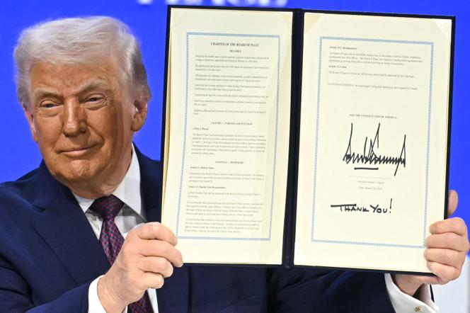 Donald Trump tient la charte fondatrice signée lors de la première réunion de son Conseil de la paix, à Davos, le 22 janvier 2026.