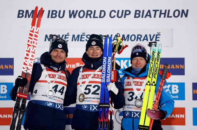 Le Français Eric Perrot célèbre, sur le podium, sa victoire sur l’individuel court, devant son compatriote Emilien Jacquelin et l’Italien Lukas Hofer, à Nove Mesto (République tchèque), le 22&nbsp;janvier&nbsp;2026.