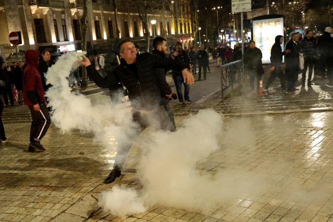 Un manifestant renvoie une grenade lacrymogène lors d’affrontements avec la police devant le bâtiment du Parlement lors d’une manifestation antigouvernementale à Tirana, le 24 janvier 2026. 