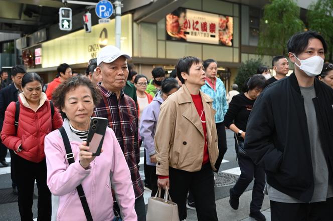 Un groupe de touristes chinois, dans une rue du quartier commerçant de Ginza, à Tokyo, le 17 novembre 2025.
