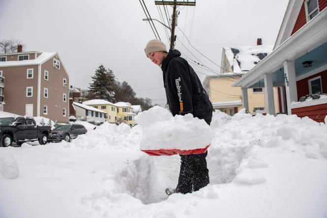 Une femme déneige sa maison à Winthrop (Massachusetts), aux Etats-Unis, le 26 janvier 2026.