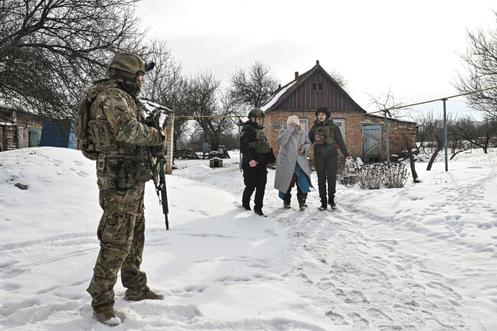 Des policiers aident une habitant à évacuer, dans un village de l’oblast de Zaporijia situé en première ligne, en Ukraine, le 27 janvier 2026.