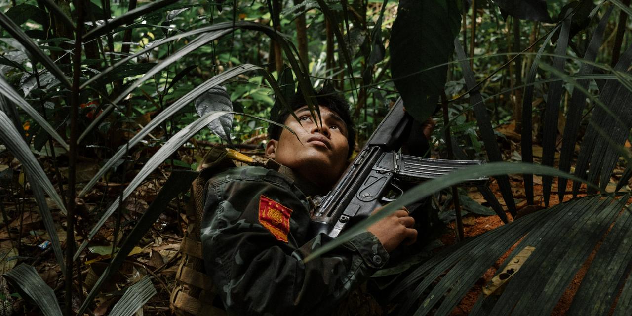 Un jeune soldat de la résistance se cache dans la végétation tandis qu'un drone de l'armée birmane passe au-dessus. Les forces de la junte sont à quelques mètres et chaque camp tente des incursions éclair. Souvent à court de munitions — « Quand chaque soldat de l'armée a 400 balles pour prendre une position, nous n'en avons à peine 150 », regrette un combattant —, les rebelles comptent sur leur connaissance du terrain et le soutien de la population. Depuis le coup d'Etat du 1er Février 2021, où la junte birmane a renverser le gouvernement civil d'Aung San Suu Kyi, la Birmanie est plongé dans une guerre civile meurtrière, ou de multiples groupes armée ethnique et prodémocratique combattent les militaires, notamment dans la région de Tanintharyi. Le 13 décembre 2025, district de Myeik, région de Tanintharyi, en Birmanie. Robin Tutenges / Hors Format

A young resistance fighter hides in the vegetation as a Burmese army drone flies overhead. Junta forces are only a few meters away, and both sides attempt rapid hit-and-run incursions. Often short of ammunition — “When each army soldier has 400 bullets to take a position, we barely have 150,” laments one fighter — the rebels rely on their knowledge of the terrain and the support of the local population. Since the coup d'Etat of February 1, 2021, in which the Burmese junta overthrew the civilian government of Aung San Suu Kyi, Myanmar has been plunged into a deadly civil war, where multiple ethnic and pro-democracy armed groups are fighting the military, particularly in the Tanintharyi region. December 13, 2025, Myeik District, Tanintharyi Region, en Birmanie. Robin Tutenges / Hors Format