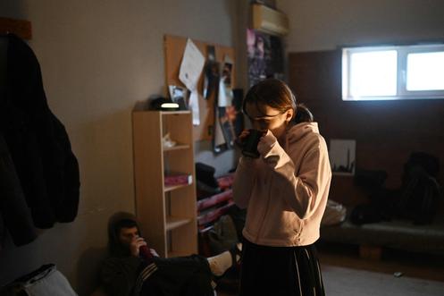 Une danseuse avec une boisson chaude pendant une pause, dans un studio de danse non chauffé à Kiev, le 29 janvier 2026.