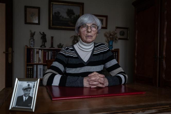 Michèle Larmier, veuve du commandant Claude Larmier, officier de marine ayant servi durant les essais nucléaires français en Polynésie, devant une photo de son défunt mari, décédé des suites d’un cancer du colon, à Vincelles (Yonne), le 30 novembre 2023.