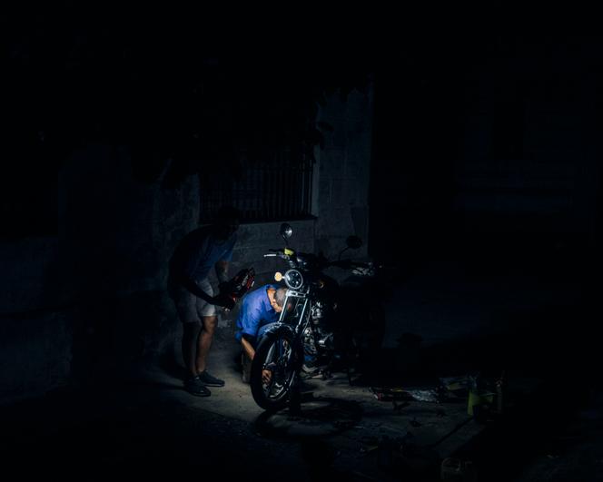 Réparation d’une moto à la lampe torche, lors d’une coupure d’électricité à Cienfuegos (Cuba), le 10 janvier 2026.