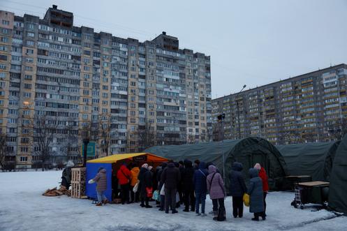 Des habitants reçoivent des repas chauds distribués par des bénévoles, dans un centre d’aide humanitaire, à Kiev, le 30 janvier 2026.