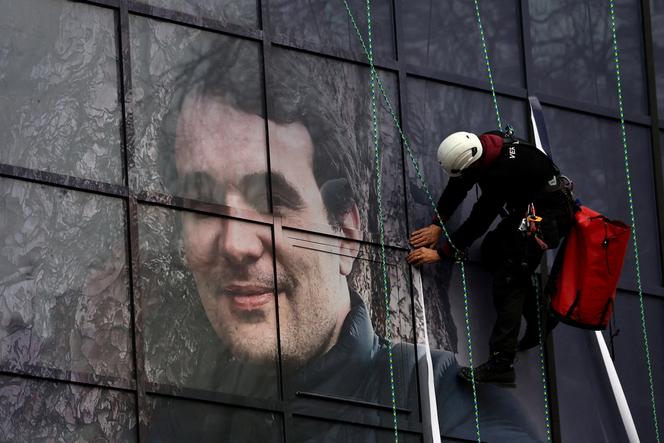 Portrait du journaliste français Christophe Gleizes, condamné à sept ans de prison par un tribunal algérien, sur la façade du siège de la Fédération française de football (FFF) à Paris, le 17 décembre 2025. 