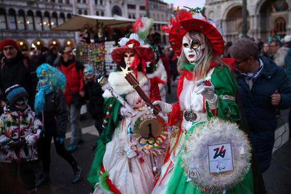 Des festivaliers en costumes aux couleurs des Jeux olympiques d’hiver de Milan-Cortina sur la place Saint-Marc lors du premier jour du carnaval de Venise (Italie), le 31 janvier 2026.