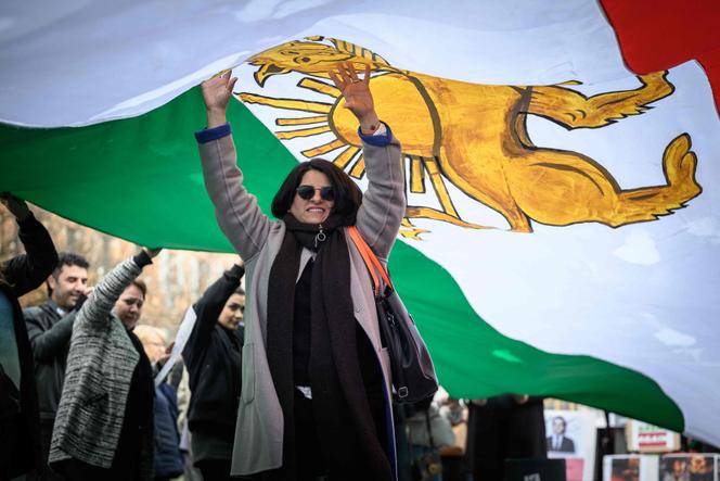 Une manifestante marche sous un drapeau iranien d’avant la révolution islamique lors d’une manifestation dénonçant la répression meurtrière du gouvernement iranien contre les manifestants, à Toulouse, dimanche 1ᵉʳ février 2026.