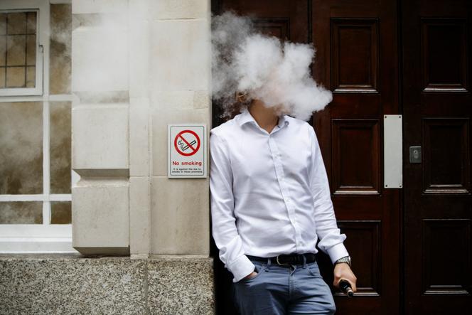 Un homme fume une cigarette électronique, dans le centre de Londres, en août 2017.