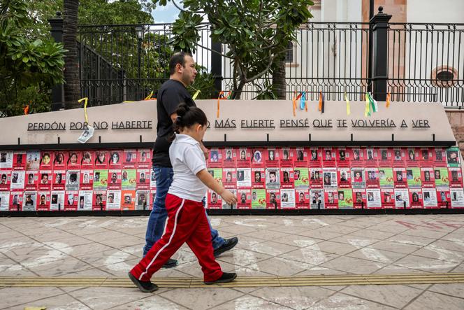 Um homem e uma jovem passam por um memorial dedicado às vítimas de desaparecimentos forçados no centro de Culiacán, estado de Sinaloa, México, em 9 de fevereiro de 2026.