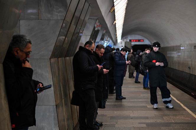 Des voyageurs consultent leur smartphone dans le métro de Moscou, le 12 février 2026.