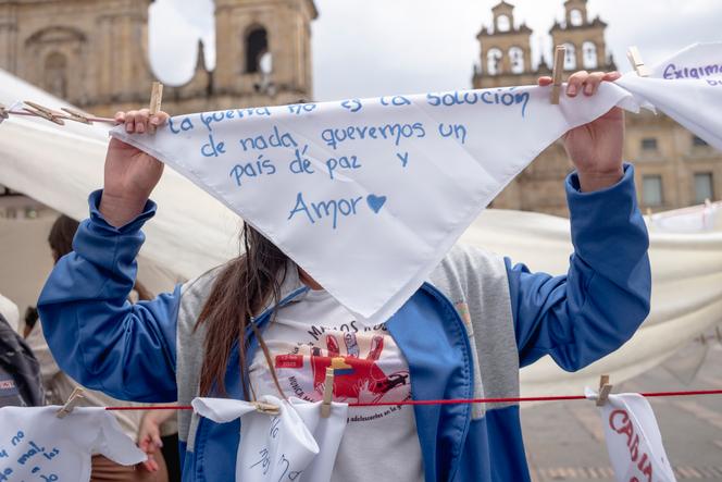 Sol, 17&nbsp;ans, résidente du centre de victimes de Benposta, cache son visage derrière un foulard blanc où il est écrit&nbsp;: «&nbsp;La guerre n’est en rien une solution, nous voulons un pays de paix et d’amour&nbsp;», lors d’une manifestation à Bogota, le 12&nbsp;février&nbsp;2026. 