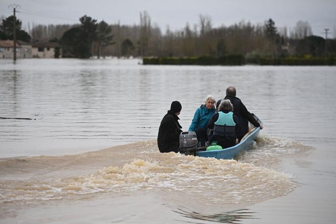 Des habitants s’entraident pour évacuer un quartier résidentiel de Tonneins après le passage de la tempête Nils, dans le sud-ouest de la France, le 13 février 2026.