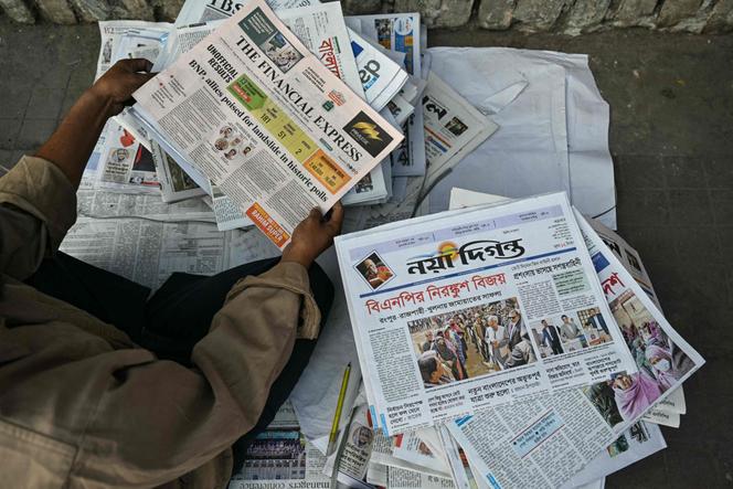 Un vendeur tient des journaux dont les premières pages couvrent les élections générales au Bangladesh à Dacca, le 13&nbsp;février&nbsp;2026.