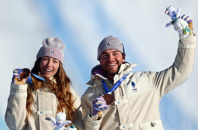 Léa Casta et Loan Bozzolo célèbrent leur médaille de bronze remportée lors de l’épreuve olympique de snowboardcross par équipes mixtes à Livigno, le 15&nbsp;février 2026.