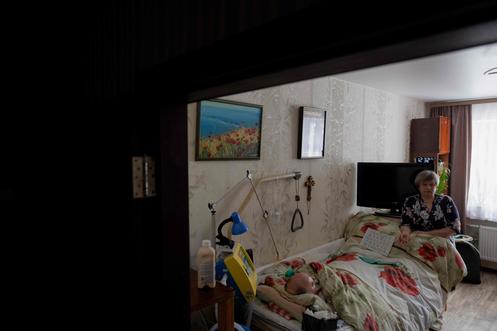 Olena, ao lado da cama do marido, em Chernihiv (Ucrânia), 12 de fevereiro de 2026.