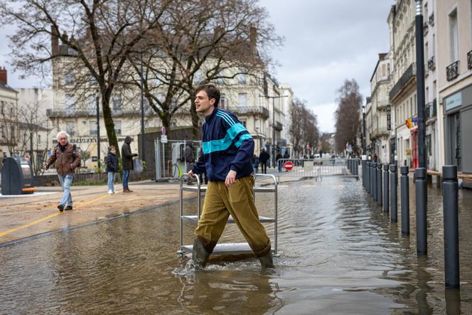 Une personne aide les gérants d’un restaurant inondé à mettre son stock à l’abri, à Angers, le 19&nbsp;février&nbsp;2026. 