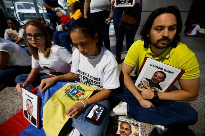 Des proches de détenus regardent sur un téléphone portable la retransmission en direct du discours du président de l’Assemblée nationale du Venezuela, Jorge Rodriguez, lors des débats sur le projet de loi d’amnistie proposé par la présidente par intérim du Venezuela, Delcy Rodriguez, devant le siège du Service bolivarien de renseignement national, à Caracas, le 19 février 2026.