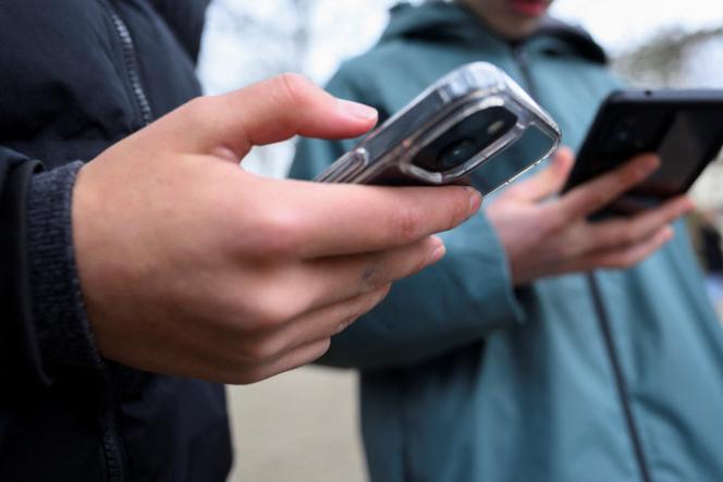 Des jeunes regardant leur téléphone, à Bonn, Allemagne, le 20 février 2026.