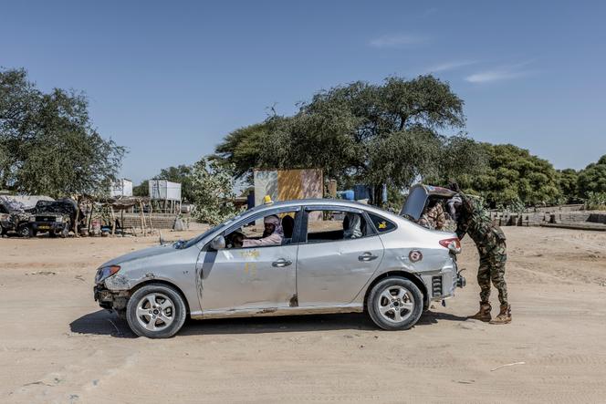 Des soldats tchadiens inspectent le coffre d’un taxi reliant le Tchad au Soudan au poste-frontière de Tiné, au Tchad, le 8 novembre 2025. 