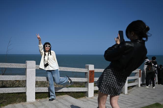 Deux femmes prennent des photos dans une zone touristique de l’île de Pingtan (Chine), le 9&nbsp;avril 2023. 