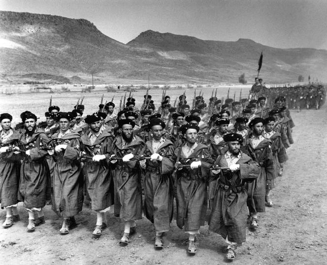 Des goumiers, soldats supplétifs fournis à l'armée française par des tribus marocaines, défilent à Kenitra, au nord de Rabat, au Maroc, en septembre 1949.