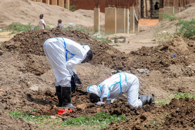 Membros do Crescente Vermelho Sudanês e especialistas forenses exumam corpos de sepulturas improvisadas no bairro de Al-Azhari, no sul, para serem enterrados novamente, em Cartum, em 2 de agosto de 2025, depois que os mortos foram enterrados às pressas sob o controle dos paramilitares das Forças de Apoio Rápido (RSF).