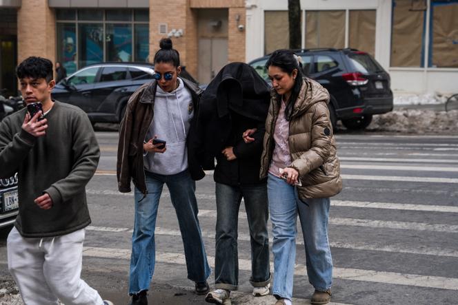 Elmina Aghayeva, étudiante en neurosciences à l’université de Columbia, est escortée jusqu’à son appartement, le visage couvert, après avoir été arrêtée par des membres de la police de l’immigration, à New York. le 26&nbsp;février 2026.