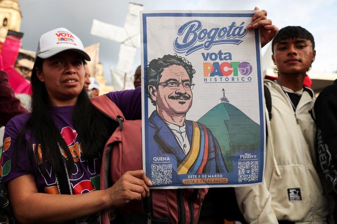 Une sympathisante du candidat à la présidence colombienne Ivan Cepeda tient une affiche à son effigie lors de la cérémonie de clôture de la campagne du Pacte historique pour les élections législatives, sur la Plaza de Bolivar, à Bogota, le 27&nbsp;février 2026. 