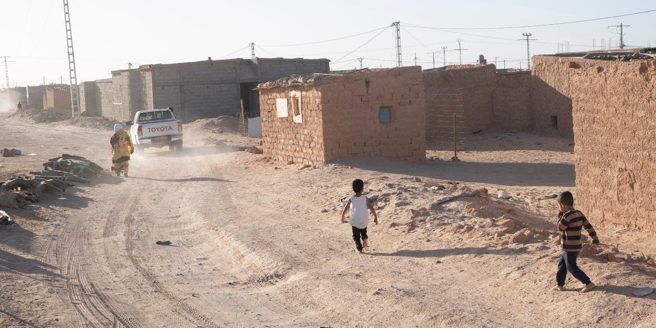 Les habitants sortent dehors quand la température baisse en fin de journée, dans le quartier de Mijek à Aousserd, campements de réfugiés sahraouis de Tindouf en Algérie, le 10 février 2026.