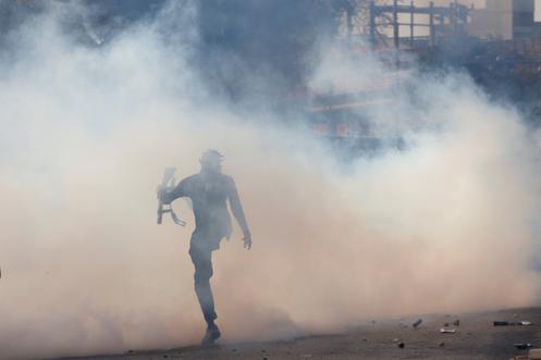 Un policier pakistanais dans un nuage de gaz lacrymogène, à Karachi, le 1ᵉʳ mars 2026.