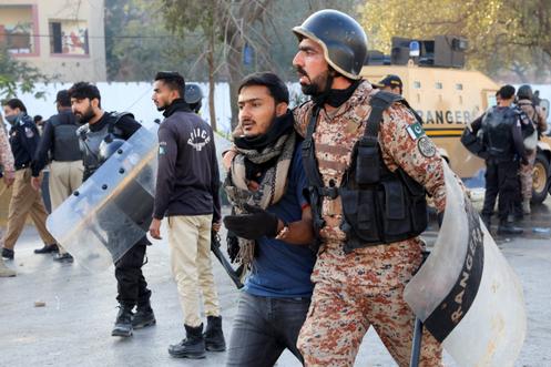 Un soldat paramilitaire arrête un homme lors d’une manifestation devant le consulat général des États-Unis, à Karachi (Pakistan), le 1ᵉʳ mars 2026.