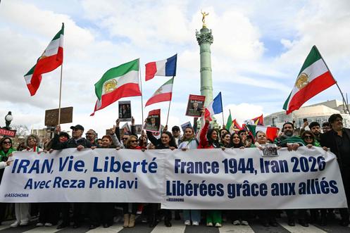 Manifestantes anti-regime iraniano brandem bandeiras iranianas decoradas com o leão e o sol, símbolos da revolução de 1979, em Paris, 1 de março de 2026.