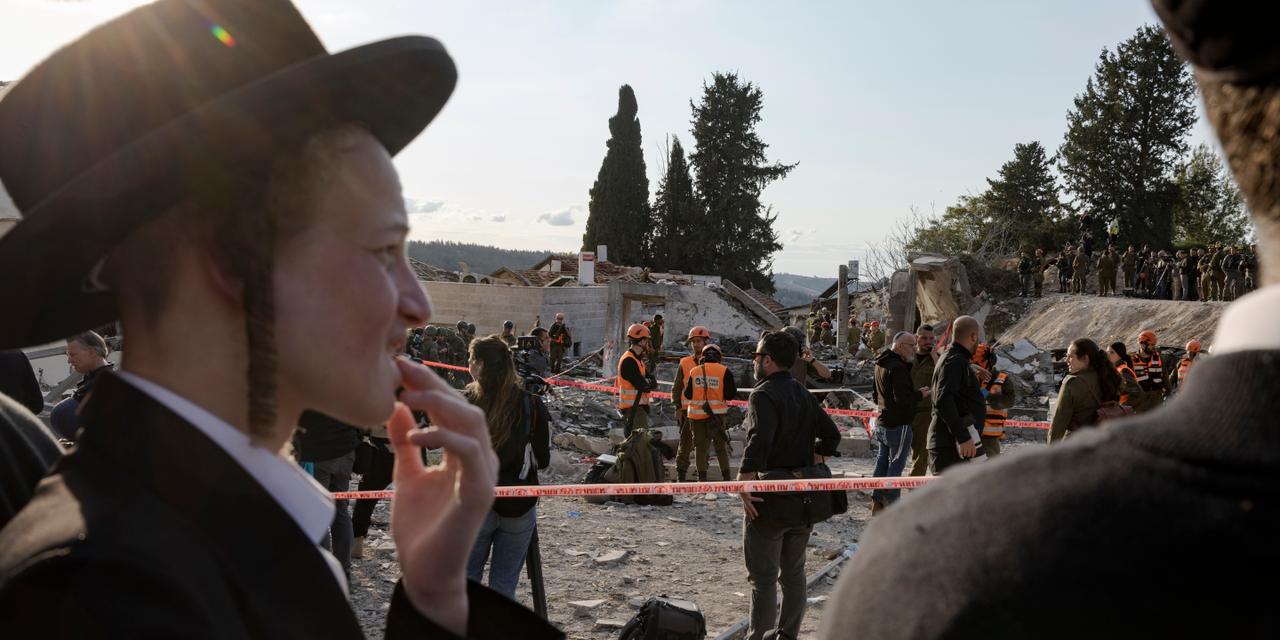 Bet Shemesh, le 1 mars 2026. Un missile est tombé sur un abri, causant environ 9 morts. Les secours cherchent encore des victimes. Des habitants regardent la scène.