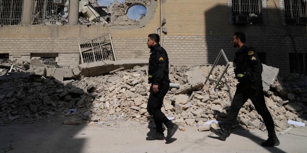 Des policiers devant un commissariat détruit par une frappe américano-israélienne, à Téhéran, le 4 mars 2026. - VAHID SALEMI/AP