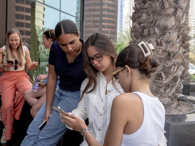 Jade, 19&nbsp;ans (gauche), Fiona, 18&nbsp;ans (centre) et Farah, 18&nbsp;ans, devant le bâtiment abritant le consulat de France à Dubaï, aux Emirats arabes unis, le 5&nbsp;mars&nbsp;2026. Elles cherchent à obtenir une solution de rapatriement. 