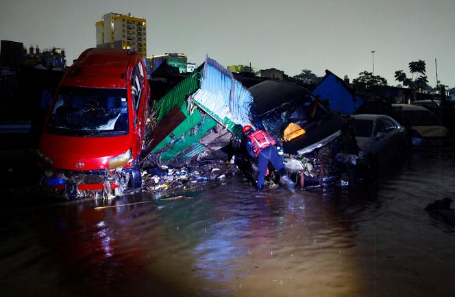 Un membre de la Croix-Rouge kenyane recherche des corps coincés dans les débris de véhicules détruits, dans le centre-ville de Nairobi, le 7 mars 2026.