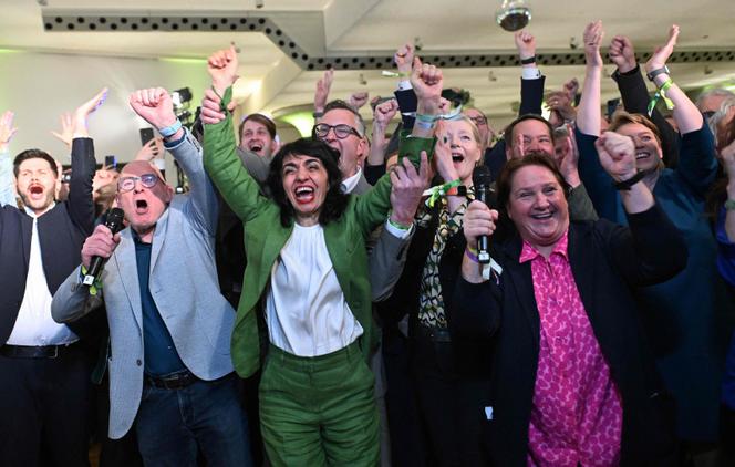 Des membres des Verts dont la présidente du Parlement du Baden-Wurtemberg Muhterem Aras (au centre), le ministre des transports Winfried Hermann (2ᵉ à gauche) et le président du groupe parlementaire des Verts Andreas Schwarz réagissent aux résultats de l’élection, le 8 mars 2026, à Stuttgart.