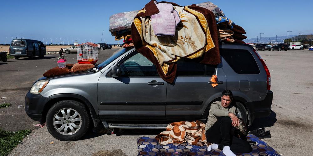 Une personne déplacée est assise à côté d’une voiture chargée d’effets personnels, à Beyrouth, le 8 mars 2026. - MOHAMED AZAKIR/REUTERS