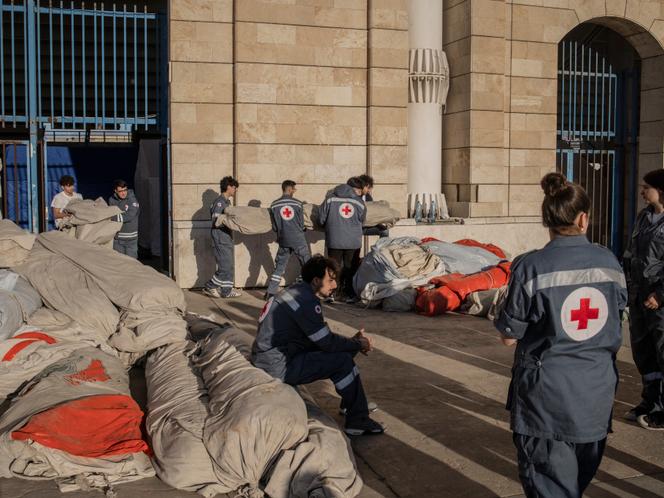 Des membres de la Croix-Rouge accueillent des déplacés libanais au stade Camille-Chamoun, à Beyrouth, le 8 mars 2026.
