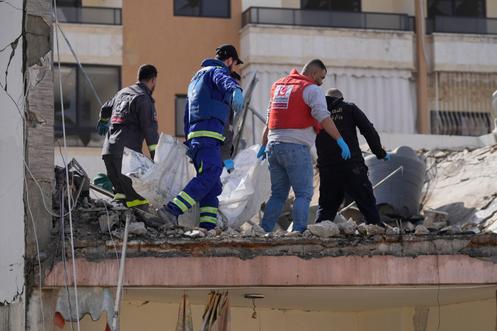 Des secouristes transportent un corps hors d’un appartement détruit par une frappe aérienne israélienne, dans la ville portuaire de Saïda, au sud du Liban, le 13 mars 2026.
