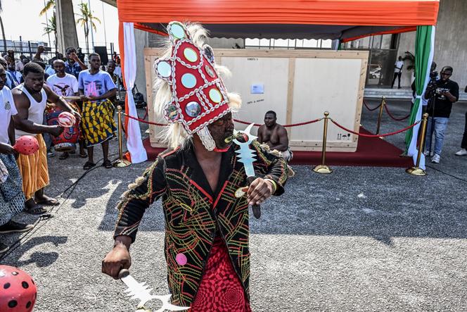 Un danseur traditionnel se produit devant la caisse contenant le « tambour parleur », à Abidjan, le 13 mars 2026.