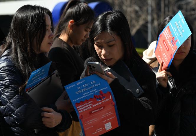 Des personnes font la queue pour faire installer OpenClaw, un assistant IA open source, sur leur ordinateur portable, au siège de Baidu, à Pékin, le 11 mars 2026.