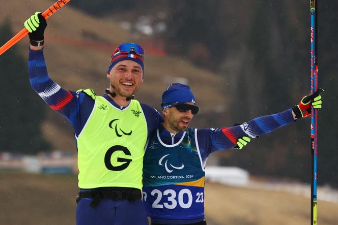 Anthony Chalençon (à esquerda), acompanhado de seu guia Florian Michelon, após a prova de esqui cross-country de 20 km nos Jogos Paraolímpicos Milão-Cortina, em Tesero (Itália), em 15 de março de 2026.