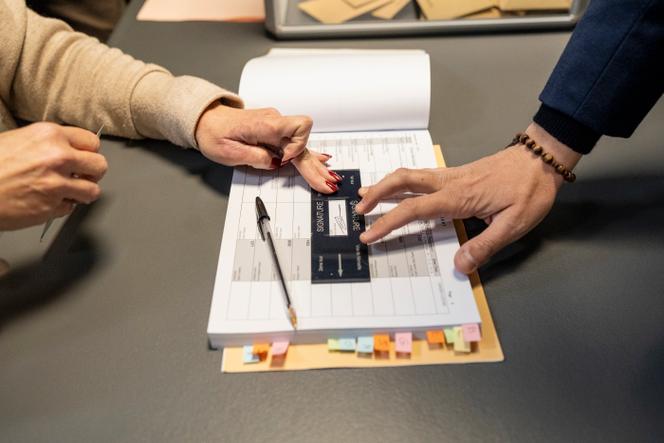 Franck Allisio signe le registre de vote de son bureau lors du premier tour des élections municipales à Marseille, le 15 mars 2026. 